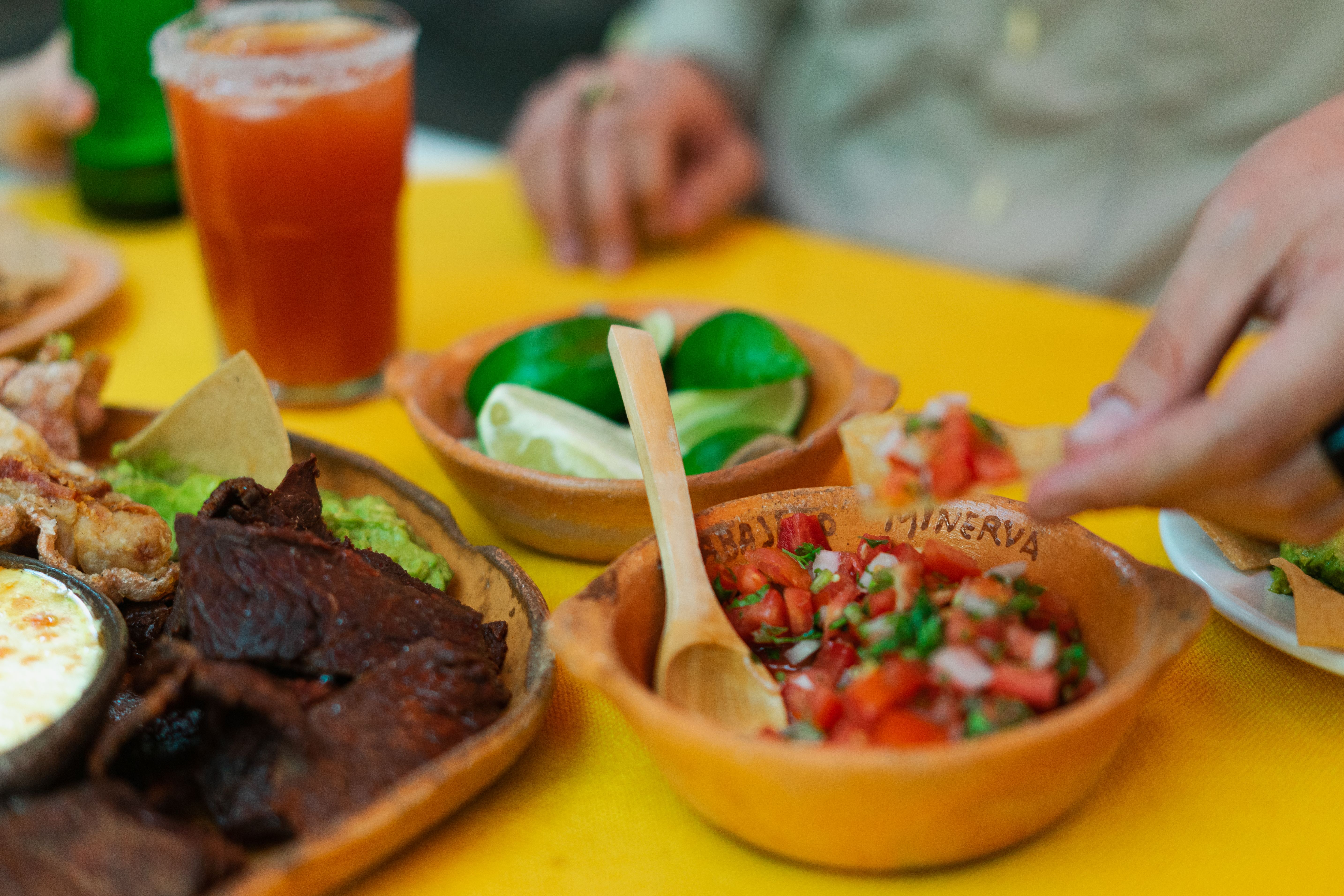 A colorful shared meal with carne, salsa, limes, and familiar Borderland foods