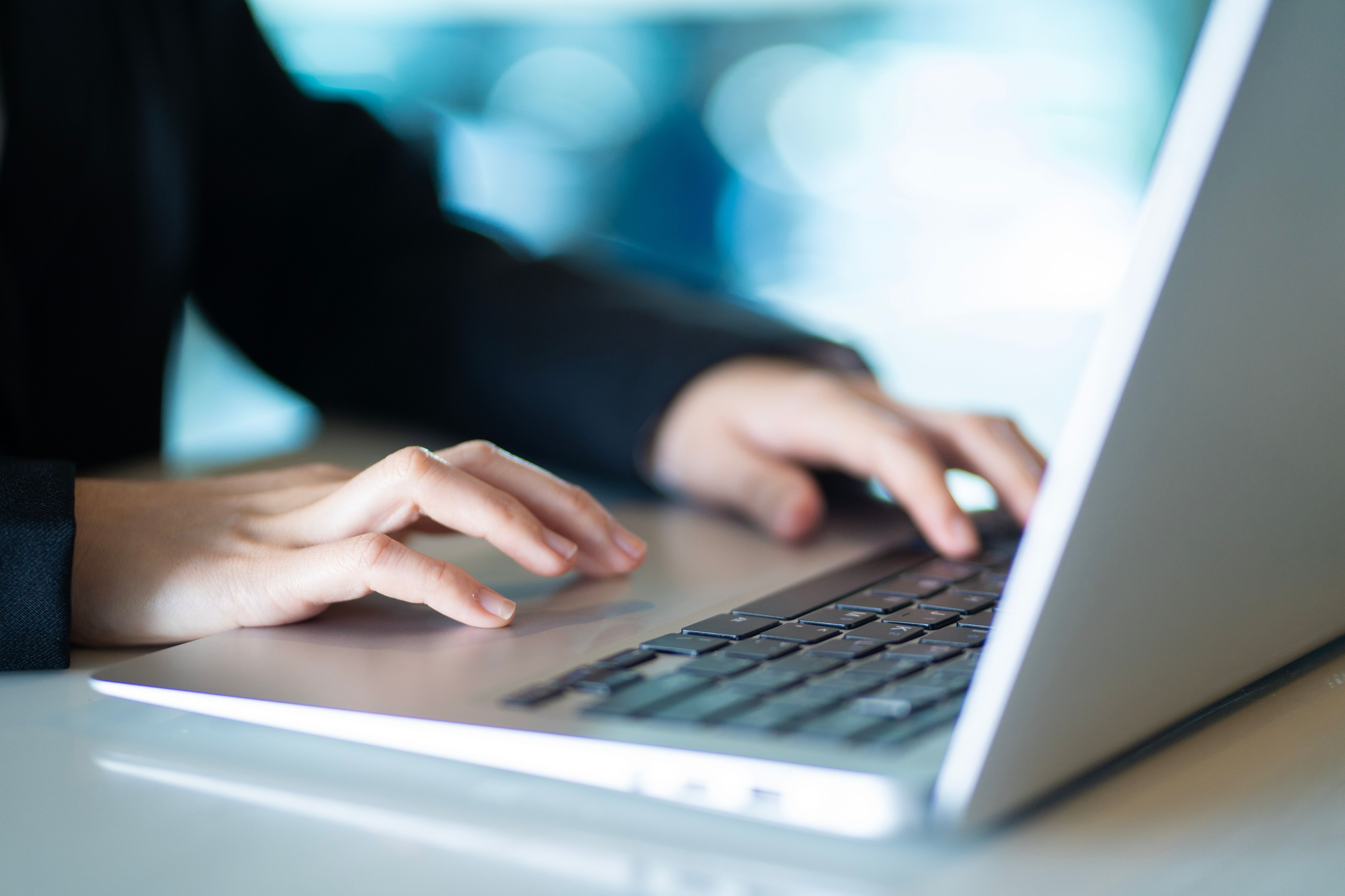 Hands using a laptop to access a secure online portal